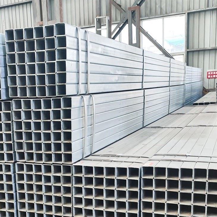 Galvanized square tube bundles being checked on arrival, with bundle tags and cut ends visible